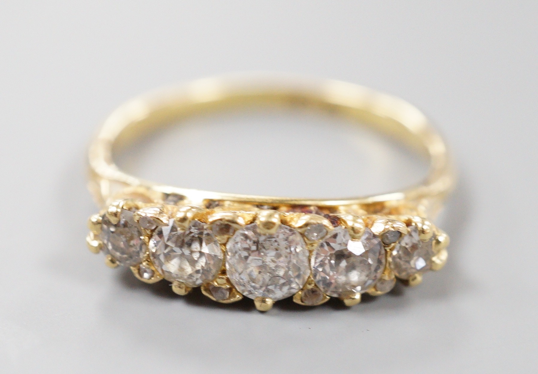 An early 20th century 18ct and graduated five stone diamond set half hoop ring, size P/Q, gross weight 3.2 grams.